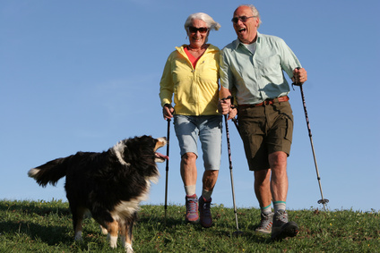 couple de séniors promenant un chien